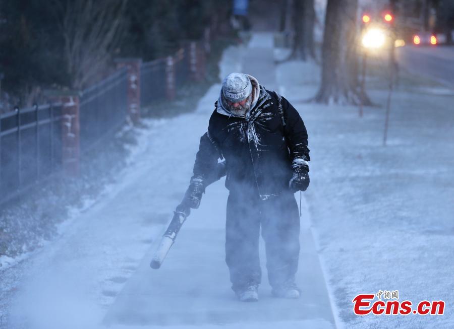 James Dusenbery blows a dusting snow off the sidewalk in Englewood, N.J., Jan. 30, 2019. The National Weather Service issued blizzard warnings for sections of upstate New York on Wednesday and officials urged people to stay inside as heavy, wind-driven snow caused whiteout conditions amid subzero windchills. (Photo/Agencies)
