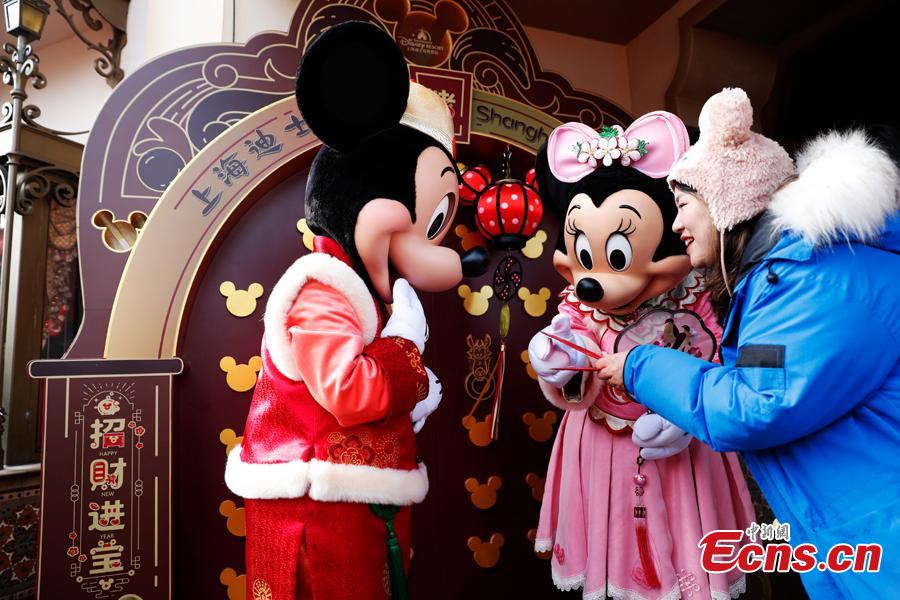 A tourist plays with Mickey and Minnie in the Shanghai Disney Resort, Jan. 1, 2019.  The Shanghai Disney launched \