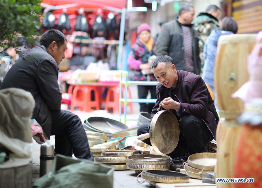 Customers select gongs, a traditional Chinese musical instrument, at a local market in Yuping Dong Autonomous County of Tongren City, southwest China\'s Guizhou Province, Jan. 31, 2019. People are busy buying goods in Guizhou for the upcoming Spring Festival, which falls on Feb. 5 this year. (Xinhua/Hu Panxue)