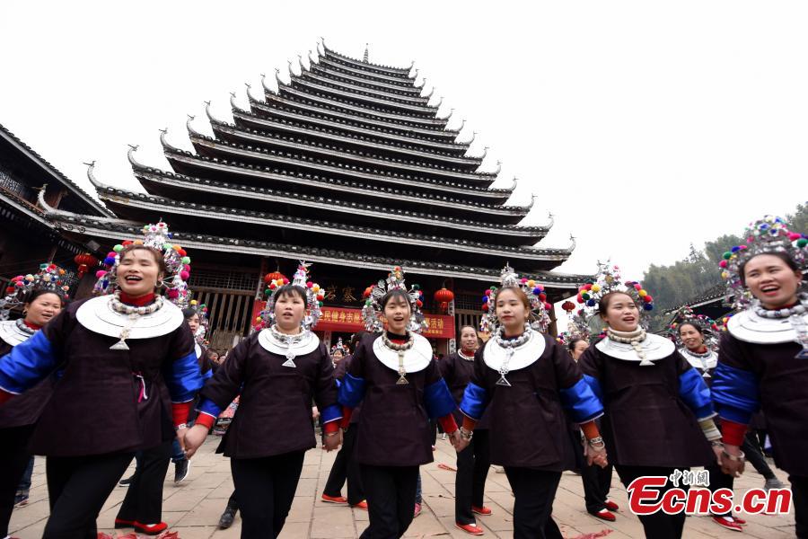 Nearly 200 women of the Dong ethnic group attend a group activity that shows the traditional custom of outmarried women going back to the home of their parents, often donning grand costumes and carrying gifts, in Pingyan Village, Sanjiang Dong Autonomous County, Guangxi Zhuang Autonomous Region, Feb. 1, 2019. The custom has become a draw that attracts tourists. (Photo: China News Service/Gong Pukang)