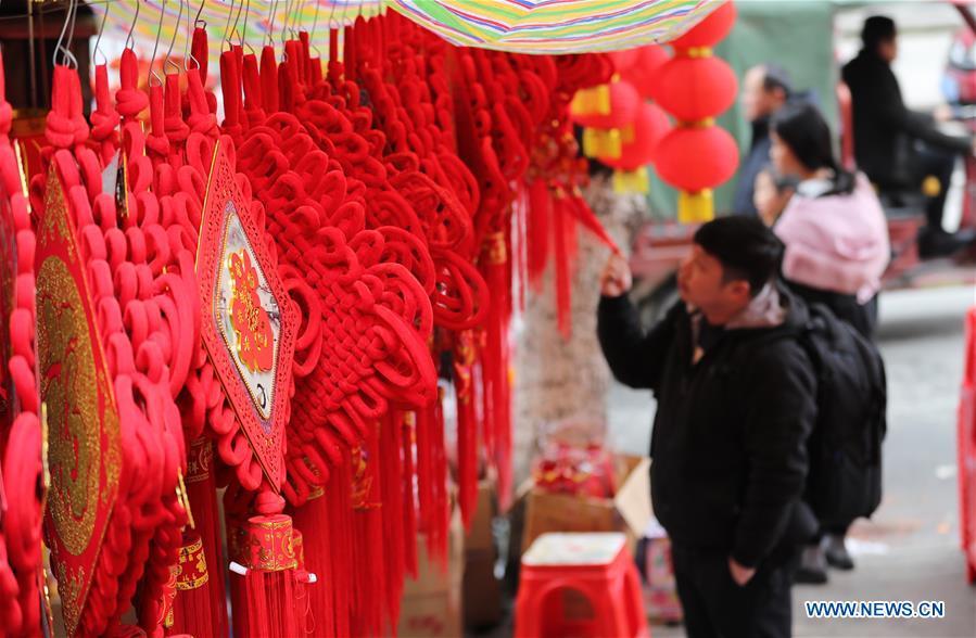 Customers select Spring Festival decorations at a local market in Yuping Dong Autonomous County of Tongren City, southwest China\'s Guizhou Province, Jan. 31, 2019. People are busy buying goods in Guizhou for the upcoming Spring Festival, which falls on Feb. 5 this year. (Xinhua/Hu Panxue)