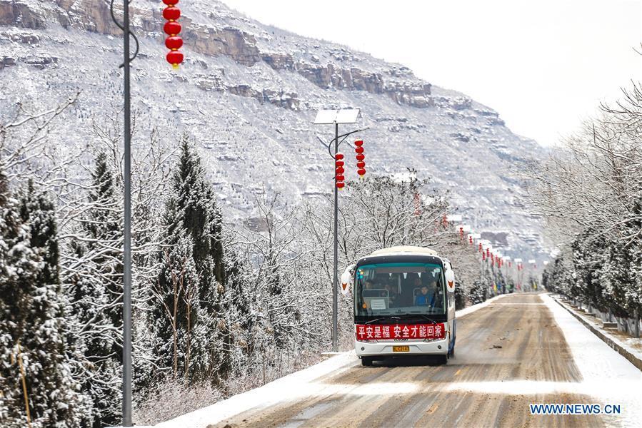 People take a sightseeing bus visiting the Hukou Waterfall of the Yellow River in Jishan County in Yuncheng, north China\'s Shanxi Province, Feb. 10, 2019. Snowfall has hit many regions in the southern part of the province since Saturday. (Xinhua/Rao Beicheng)