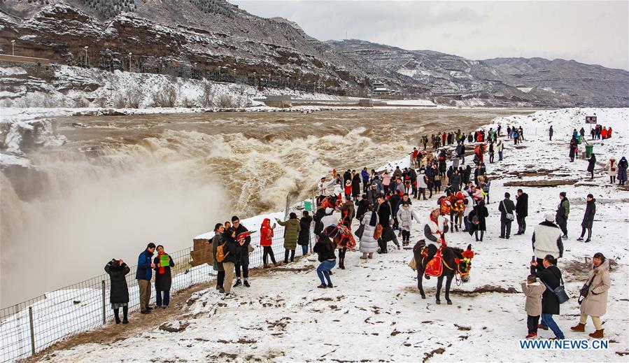 Tourists view the Hukou Waterfall of the Yellow River in snow in Jixian County, north China\'s Shanxi Province, Feb. 10, 2019. Snowfall has hit many regions in the southern part of the province since Saturday. (Xinhua/Rao Beicheng)