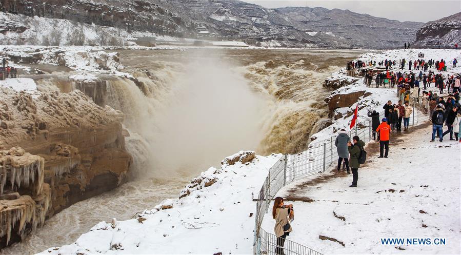 Tourists view the Hukou Waterfall of the Yellow River in snow in Jixian County, north China\'s Shanxi Province, Feb. 10, 2019. Snowfall has hit many regions in the southern part of the province since Saturday. (Xinhua/Rao Beicheng)