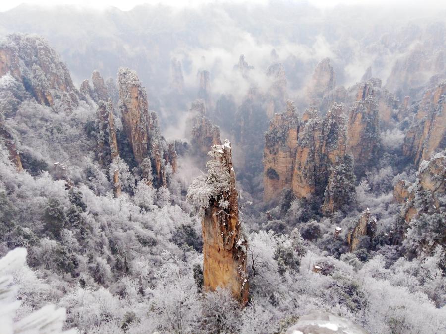 Mountains and plants are covered with ice as clouds float by at the Tianzi Mountain scenic area in Zhangjiajie City, Central China\'s Hunan Province, Feb. 11, 2019. (Photo: China News Service/Deng Daoli)