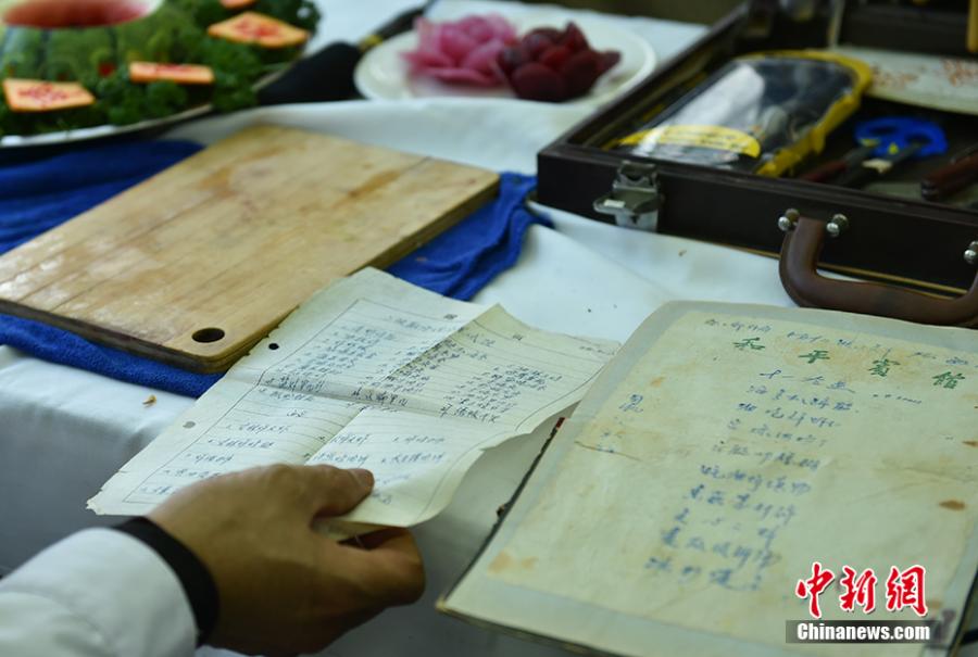 Wang Jinliang shows his notes about cooking food in Beijing during Spring Festival, China\'s Lunar New Year. Wang, 59, has worked on trains for more than 40 years, starting as a cook in 1978 before moving to roles as chef, kitchen head and now Party chief of the passengers service department. As the 2019 Spring Festival was his last one on duty, he spent 80 yuan ($12) buying fruits and vegetables including watermelon, carrot and Chinese cabbage to show his carving creations. Wang also said his skill in making fancy food garnishes enabled him to contribute to marking important occasions in his job, such as the first train from Beijing to Shenzhen in 1996. (Photo: China News Service/Zhai Lu)