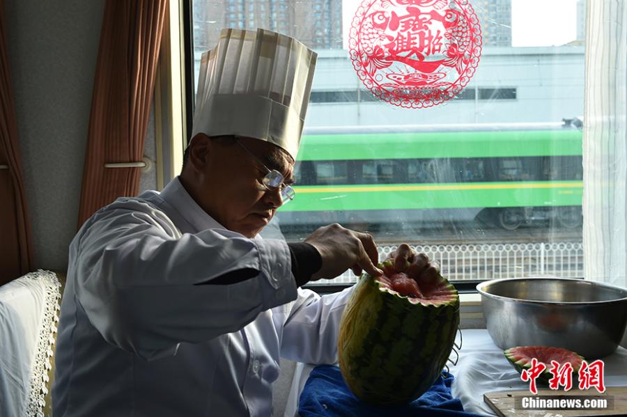 Wang Jinliang carves a watermelon on a train in Beijing during Spring Festival, China\'s Lunar New Year. Wang, 59, has worked on trains for more than 40 years, starting as a cook in 1978 before moving to roles as chef, kitchen head and now Party chief of the passengers service department. As the 2019 Spring Festival was his last one on duty, he spent 80 yuan ($12) buying fruits and vegetables including watermelon, carrot and Chinese cabbage to show his carving creations. Wang also said his skill in making fancy food garnishes enabled him to contribute to marking important occasions in his job, such as the first train from Beijing to Shenzhen in 1996. (Photo: China News Service/Zhai Lu)