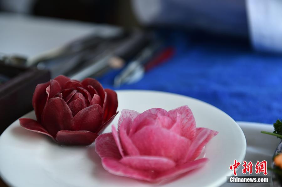 Wang Jinliang shows his food carving creations on a train in Beijing during Spring Festival, China\'s Lunar New Year. Wang, 59, has worked on trains for more than 40 years, starting as a cook in 1978 before moving to roles as chef, kitchen head and now Party chief of the passengers service department. As the 2019 Spring Festival was his last one on duty, he spent 80 yuan ($12) buying fruits and vegetables including watermelon, carrot and Chinese cabbage to show his carving creations. Wang also said his skill in making fancy food garnishes enabled him to contribute to marking important occasions in his job, such as the first train from Beijing to Shenzhen in 1996. (Photo: China News Service/Zhai Lu)