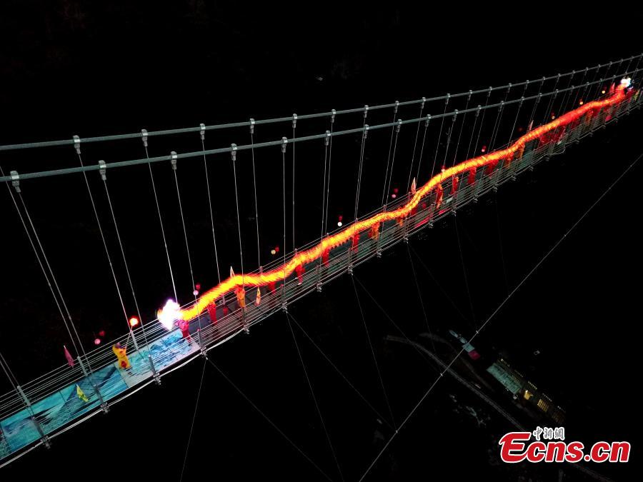 As part of Spring Festival celebrations, local people perform a dragon dance on a suspended glass bridge, some 200 meters above the ground, at a scenic area in Youxi County, East China\'s Fujian Province, Feb. 12, 2019.  (Photo: China News Service/Wang Dongming)