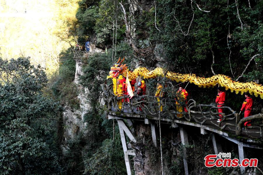 As part of Spring Festival celebrations, local people perform a dragon dance on a suspended glass bridge, some 200 meters above the ground, at a scenic area in Youxi County, East China\'s Fujian Province, Feb. 12, 2019.  (Photo: China News Service/Wang Dongming)