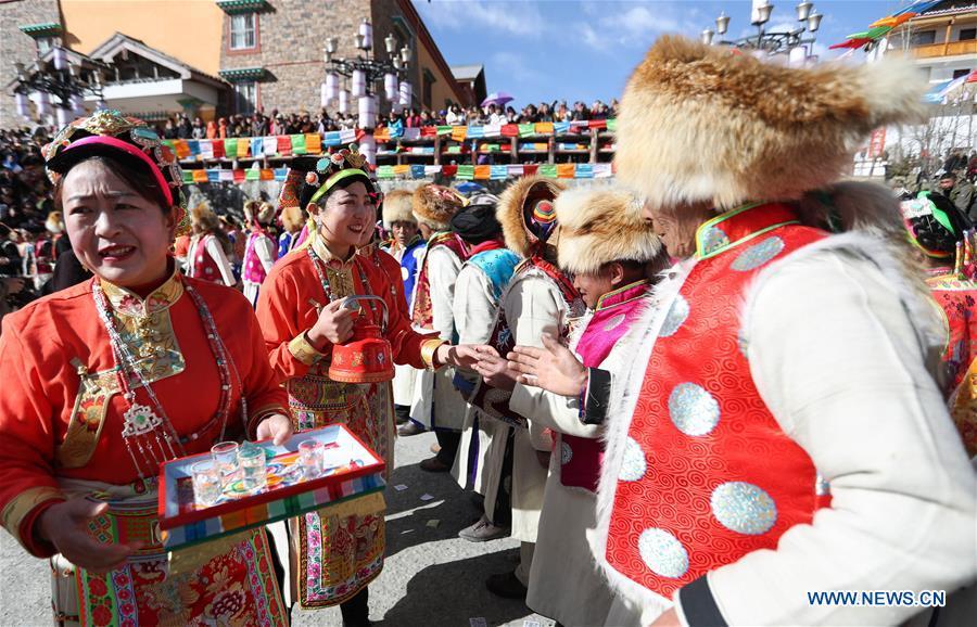 People of Tibetan ethnic group serve alcoholic drink during the Shangjiu Festival at the foot of Jiajin Mountain in the Tibetan Township of Qiaoqi in Ya\'an City, southwest China\'s Sichuan Province, Feb. 13, 2019. The Shangjiu Festival, a traditional festival of the Tibetan people, is celebrated on the ninth day of the first lunar month to pray for a good harvest. (Xinhua/Jiang Hongjing)