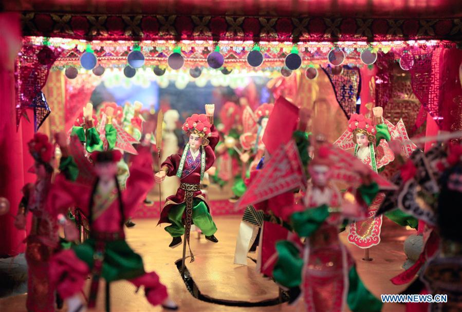 Photo taken on Feb. 11, 2019 shows figures on ornamental dragon in Beibaixiang Town of Yueqing, east China\'s Zhejiang Province. Having a history of more than 400 years, the ornamental dragon, a sacrifice to pray for good fortune during the period of Lantern Festival, is popular in villages of Yueqing City in Zhejiang Province. Lin Shunkui, an inheritor of the handicraft of ornamental dragon, is born in 1956 in Dongchan Village of Beibaixiang Town. Learning the art since he was young from his father, who is a master of fine paper-cutting, Lin has been in the walk for more than 40 years and has been famous for his exquisite handicraft. The making procedures of the ornamental dragon require high standards and needs preparation of more than half a year. The craftsman must be proficient in various vocations such as paper-cutting, carpentry, painting and machinery. Usually having a height of four meters, a length of three meters and a width of two meters, the ornamental dragon displays about 300 figures in more than 80 cabinets, which are driven by gears hidden inside the dragon body. The handicraft of ornamental dragon was listed as one of the national intangible cultural heritages in October of 2014. (Xinhua/Zhu Weixi)