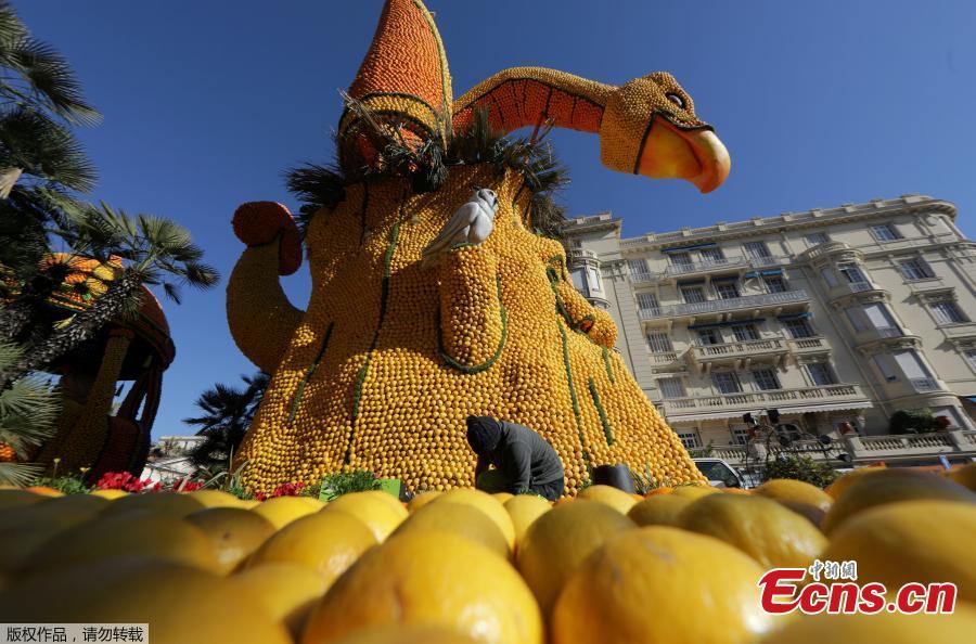 A worker puts the final touch to a sculpture made with lemons and oranges which depicts Dragon Nest during the 86th Lemon festival around the theme \