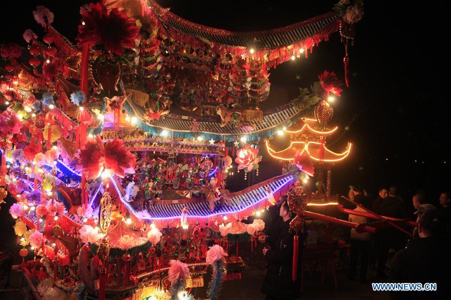 Villagers participate in the ornamental dragon parade in Xiliuzhai Village of Beibaixiang Town of Yueqing, east China\'s Zhejiang Province, Feb. 12, 2019. Having a history of more than 400 years, the ornamental dragon, a sacrifice to pray for good fortune during the period of Lantern Festival, is popular in villages of Yueqing City in Zhejiang Province. Lin Shunkui, an inheritor of the handicraft of ornamental dragon, is born in 1956 in Dongchan Village of Beibaixiang Town. Learning the art since he was young from his father, who is a master of fine paper-cutting, Lin has been in the walk for more than 40 years and has been famous for his exquisite handicraft. The making procedures of the ornamental dragon require high standards and needs preparation of more than half a year. The craftsman must be proficient in various vocations such as paper-cutting, carpentry, painting and machinery. Usually having a height of four meters, a length of three meters and a width of two meters, the ornamental dragon displays about 300 figures in more than 80 cabinets, which are driven by gears hidden inside the dragon body. The handicraft of ornamental dragon was listed as one of the national intangible cultural heritages in October of 2014. (Xinhua/Zhu Weixi)