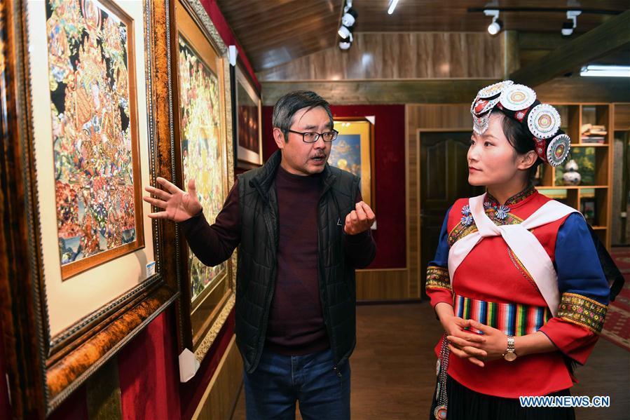 Fan Yongzhen (R), deputy to China\'s 13th National People\'s Congress (NPC), carries out a research on Thangka Budda Painting with dianxiu embroidery at Baisha Old Town of Yulong Naxi Autonomous County in Lijiang, southwest China\'s Yunnan Province, Feb. 13, 2019. Working as vice curator of the Cultural Center in Lijiang city, Fan has devoted herself to the career of protecting and promoting local ethnic cultures. Besides, she also contributes to the mass culture construction work by sending performances to rural areas together with her colleagues. As a deputy to NPC, China\'s top legislature, Fan will put more efforts into the building of cultural industries integrated with digital technologies in underdeveloped areas so as to improve local cultural development. (Xinhua/Yang Zongyou)