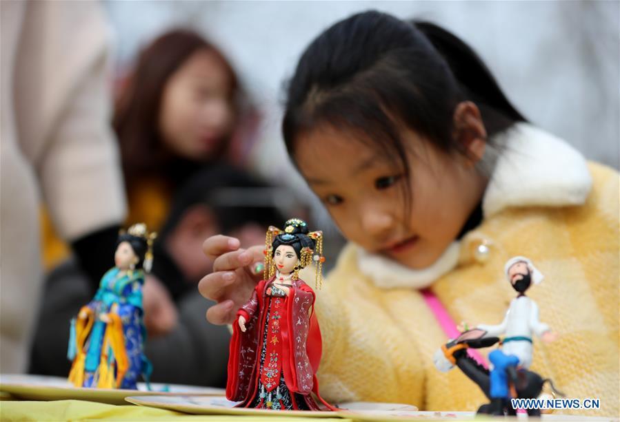 A child watches the dough modelling exhibited on the annual dough modelling exhibition held in Nanzhang Village of Xiulin Town in Jingxing County, Shijiazhuang, capital of north China\'s Hebei Province, on Feb. 22, 2019. The exquisitely crafted and colorful dough modelling on display attracted a great number of visitors to appreciate the beauty. The Nanzhang dough modelling was listed as one of the provincial level intangible cultural heritages in 2011. (Xinhua/Wang Baolong)