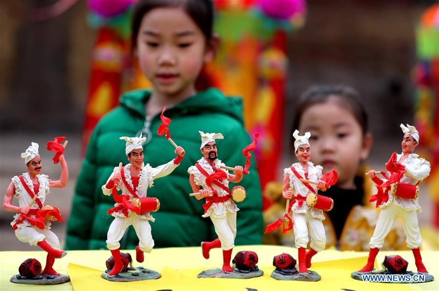 Two children watch the dough modelling exhibited on the annual dough modelling exhibition held in Nanzhang Village of Xiulin Town in Jingxing County, Shijiazhuang, capital of north China\'s Hebei Province, on Feb. 22, 2019. The exquisitely crafted and colorful dough modelling on display attracted a great number of visitors to appreciate the beauty. The Nanzhang dough modelling was listed as one of the provincial level intangible cultural heritages in 2011. (Xinhua/Wang Baolong)