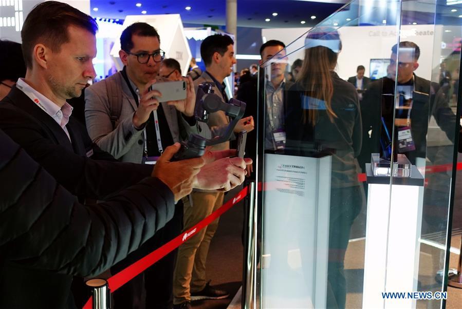 Visitors take pictures of a Huawei MATE X, a foldable 5G ready smartphone, displayed at the 2019 Mobile World Congress (MWC) in Barcelona, Spain, Feb. 25, 2019. The four-day 2019 MWC opened on Monday in Barcelona. (Xinhua/Guo Qiuda)