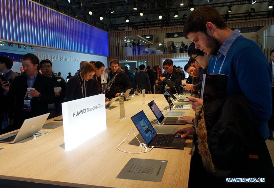 Visitors try on Huawei MateBook X Pro laptops at the 2019 Mobile World Congress (MWC) in Barcelona, Spain, Feb. 25, 2019. The four-day 2019 MWC opened on Monday in Barcelona. (Xinhua/Guo Qiuda)