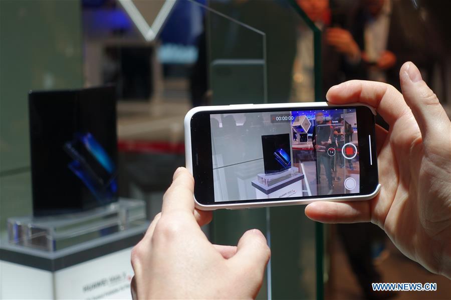 A visitor takes pictures of a Huawei MATE X, a foldable 5G ready smartphone, displayed at the 2019 Mobile World Congress (MWC) in Barcelona, Spain, Feb. 25, 2019. The four-day 2019 MWC opened on Monday in Barcelona. (Xinhua/Guo Qiuda)
