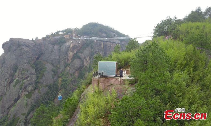 A view of a newly-opened hostel on top of a cliff, 523 meters above the ground, at the Shiniuzhai National Geological Park in Pingjiang County, Central China\'s Hunan Province, Feb. 27, 2019. Guests are treated to an impressive view of the park as the accommodation’s room walls are made of glass. (Photo: China News Service/Yang Huafeng)