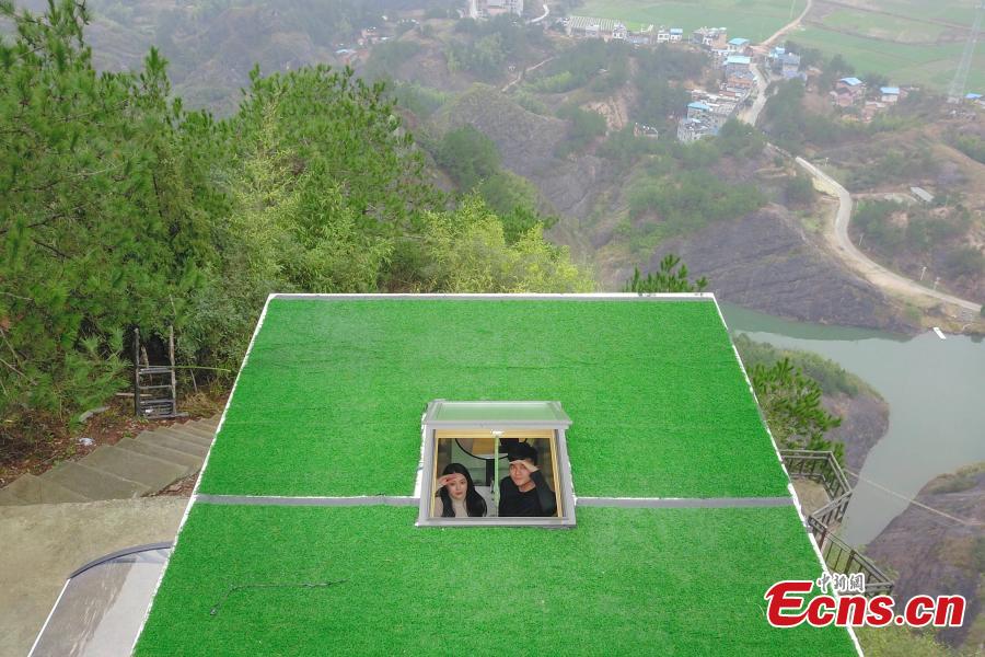 A view of a newly-opened hostel on top of a cliff, 523 meters above the ground, at the Shiniuzhai National Geological Park in Pingjiang County, Central China\'s Hunan Province, Feb. 27, 2019. Guests are treated to an impressive view of the park as the accommodation’s room walls are made of glass. (Photo: China News Service/Yang Huafeng)