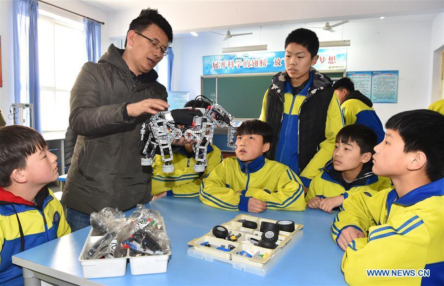A teacher shows students how to assemble a model in Hanjiawa Middle School of Gaocheng District, Shijiazhuang City, north China\'s Hebei Province, Feb. 28, 2019. A series of activities including dancing, model-assembling and calligraphy have enriched children\'s extra-curricular life and guaranteed their all-round development. (Xinhua/Zhang Xiaofeng)