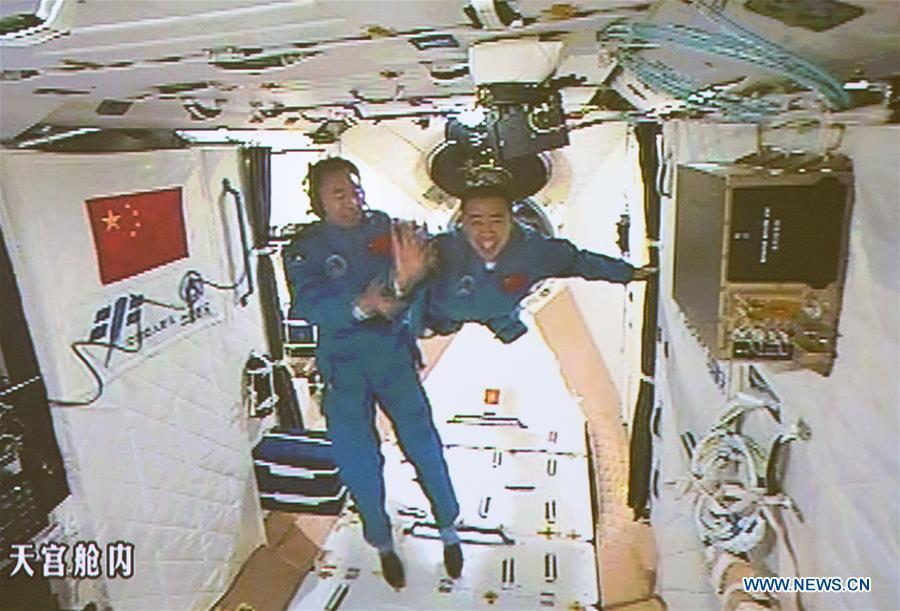 The screen at the Beijing Aerospace Control Center shows the two Chinese astronauts Jing Haipeng (L) and Chen Dong entering the space lab Tiangong-2, Oct. 19, 2016. The China Manned Space Engineering Office (CMSEO) announced Monday that the core module of the country\'s space station, the Long March-5B carrier rocket and its payloads will be sent to the launch site in the second half of this year, to make preparations for the space station missions. China is scheduled to complete the construction of the space station around 2022. It will be the country\'s space lab in long-term stable in-orbit operation. (Xinhua/Ju Zhenhua)