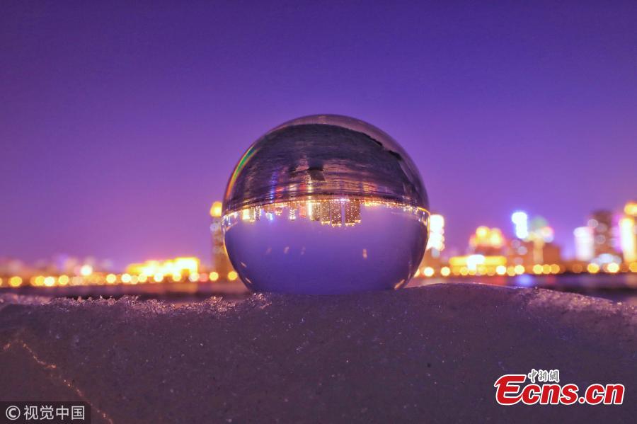 Refraction photography using a crystal ball on ice shows a view of the landscape near the Songhua River in Harbin City, Heilongjiang Province, March 4, 2019. (Photo/VCG)