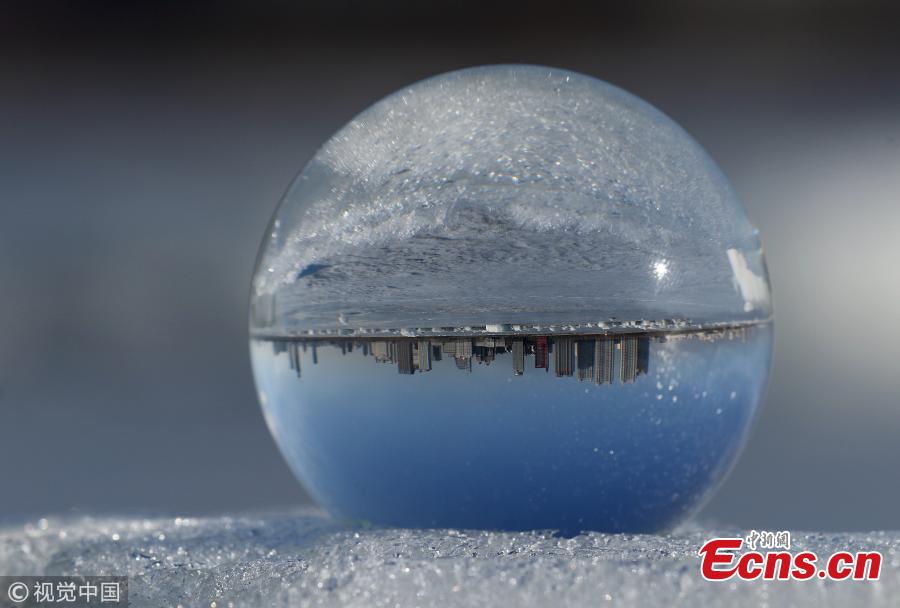 Refraction photography using a crystal ball on ice shows a view of the landscape near the Songhua River in Harbin City, Heilongjiang Province, March 4, 2019. (Photo/VCG)