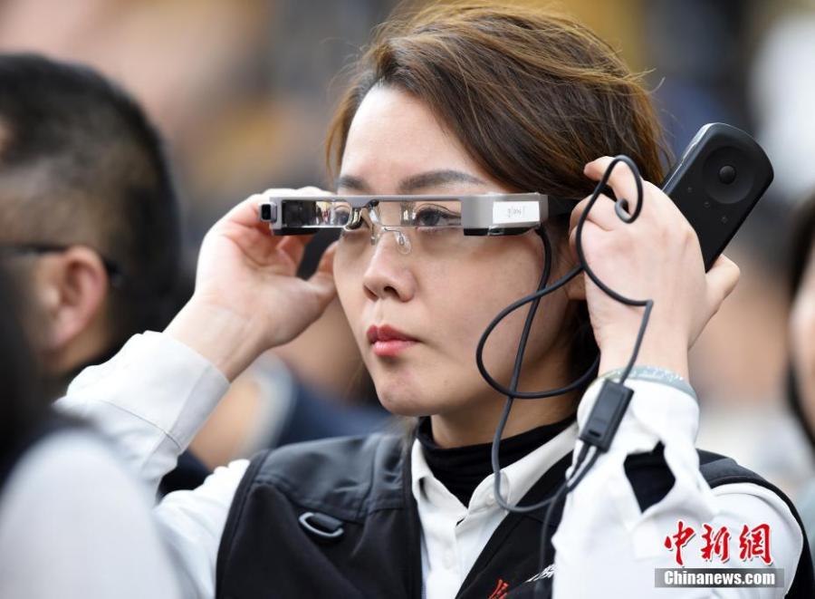 A reporter wears virtual reality (VR) glasses while covering the second session of the 13th National People\'s Congress at the Great Hall of the People in Beijing on Tuesday, March 5, 2019. The VR glasses can record the voice of the wearer, and the tiny camera installed on the frame of the glasses can capture high-definition videos. (Photo/China News Service)