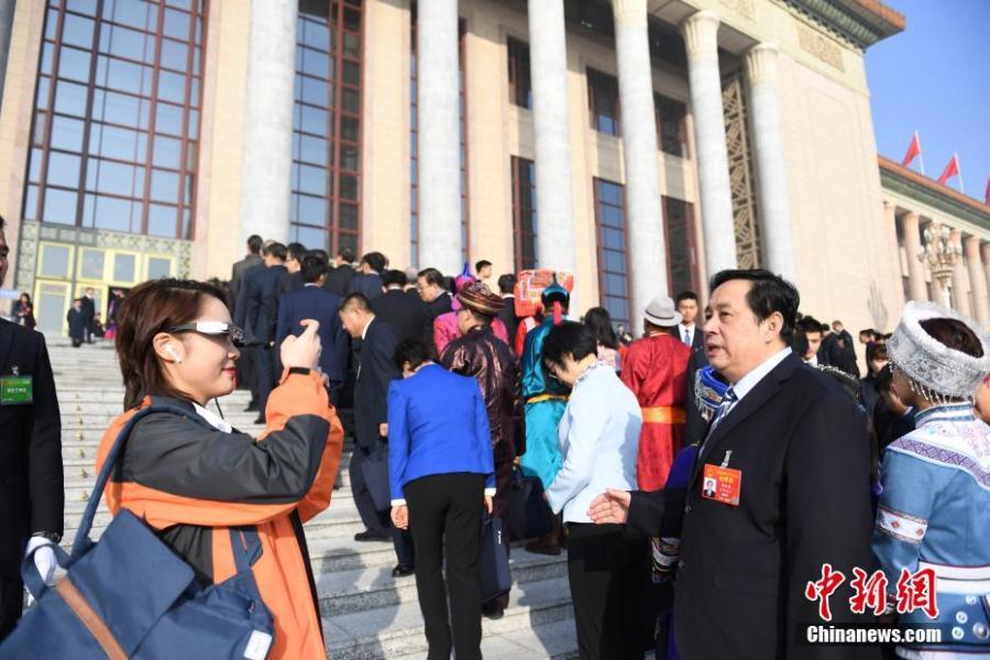 A reporter wears virtual reality (VR) glasses while covering the second session of the 13th National People\'s Congress at the Great Hall of the People in Beijing on Tuesday, March 5, 2019. The VR glasses can record the voice of the wearer, and the tiny camera installed on the frame of the glasses can capture high-definition videos. (Photo/China News Service)
