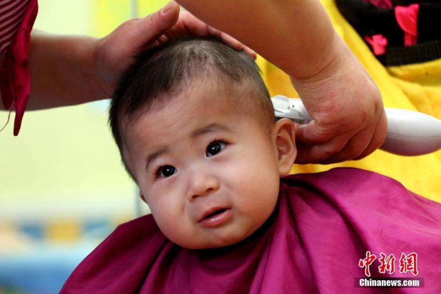 A child gets a haircut in Zaozhuang City, Shandong Province, March 8, 2019. March 8 marks traditional Chinese festival Long Tai Tou (dragon head raising), which refers to the start of spring and farming. During the festival, held on the second day of the second month of the lunar calendar, people play dragon lanterns, eat noodles, shave their hair, and pray for luck. (Photo: China News Service/Ji Zhe)