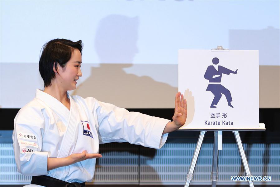 Japanese karate athlete Kiyo Shimizu takes the same action as the one Karate Kata pictogram shows at Tokyo 2020 Summer Olympic Games sport pictograms unveiling event in Tokyo, Japan, on March 12, 2019. (Xinhua/Du Xiaoyi)