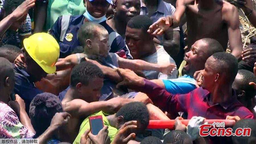 Rescue workers help carry a child at the site of a collapsed building containing a school in Nigeria\'s commercial capital Lagos, Nigeria March 13, 2019. As many as 100 children and many others were feared trapped on Wednesday after the building collapsed. (Photo/Agencies)