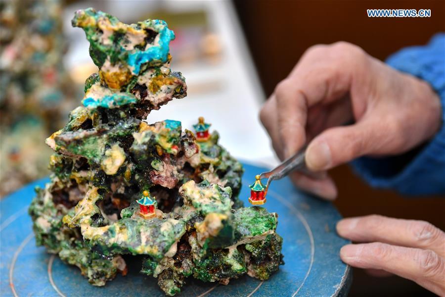 Ge Yuansheng, inheritor of coloured glaze firing skill, a national intangible cultural heritage listed in 2008, works on a piece of coloured glaze made of coal cinder at his workshop in Taiyuan, north China\'s Shanxi Province, March 13, 2019. Ge has been applying his skill of coloured glaze firing to waste coal cinder for five years. After going through dozens of processes, the waste material would be made into delicate artwork. (Xinhua/Cao Yang)