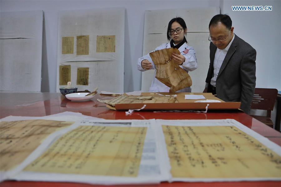 Wang Zongxun (R), curator of a museum of Jinping Writs, guides staff workers in regulating the documents at the museum in Jinping County, southwest China\'s Guizhou Province, March 18, 2019. Dating back to the Ming Dynasty (1368-1644), \