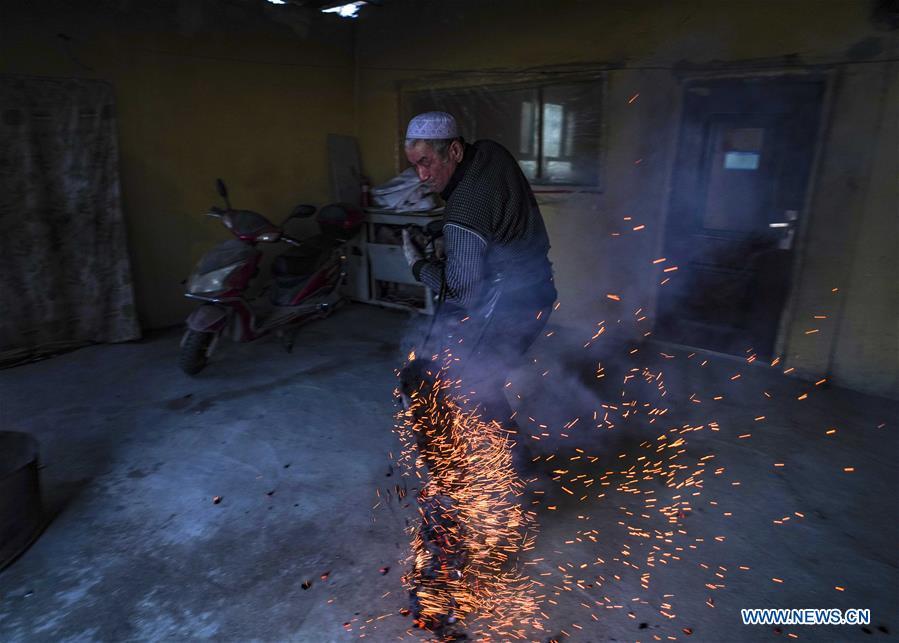 A baker deals with wood fire taken out of an oven at Daxi Village of Yuli County, northwest China\'s Xinjiang Uygur Autonomous Region, Jan. 29, 2019. Daxi Village is famous for its \