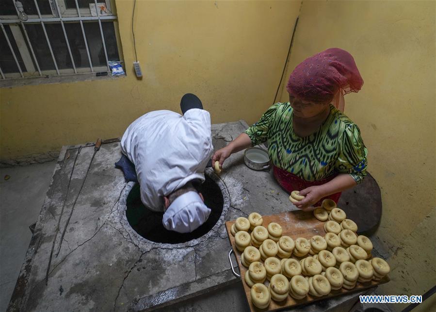 A woman helps her husband put doughs of \