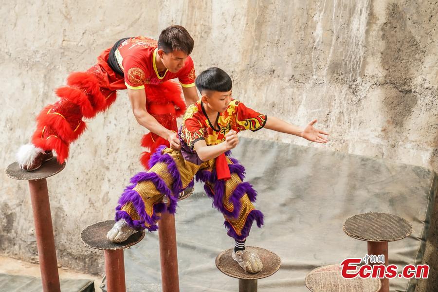Tang Yifeng (L), a sixth grader, learns about lion dance in Tengxian County, Wuzhou City, South China\'s Guangxi Zhuang Autonomous Region, March 18, 2019. Tengxian is home to a special folk lion dance. The dance troupe, which formed in 1997, has won many top awards in contests, and its unique stunts that imitate a drunken lion or a lion climbing a cliff, for example, are particularly mind-blowing. (Photo: China News Service/Chen Guanyan)