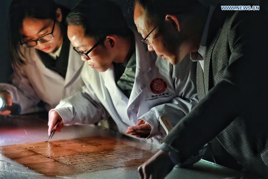 Wang Zongxun (R), curator of a museum of Jinping Writs, guides as staff workers restore a document at the museum in Jinping County, southwest China\'s Guizhou Province, March 18, 2019. Dating back to the Ming Dynasty (1368-1644), \