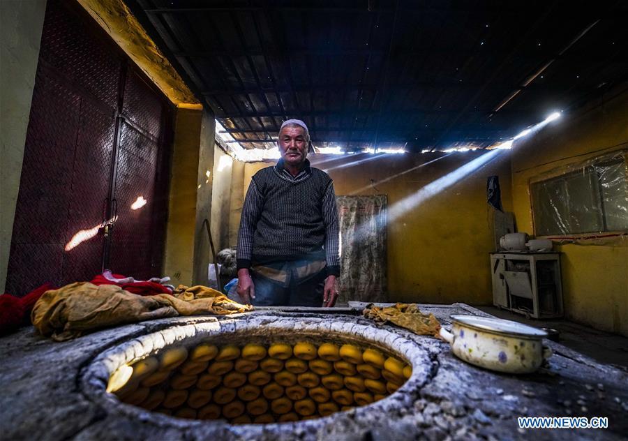 A baker is seen behind a heated oven baking \