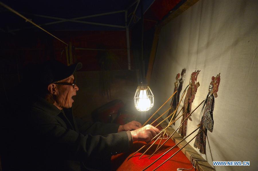 Chang Bingzhang plays the shadow puppet performance at Luyuan Township of Weiyuan County in Dingxi City, northwest China\'s Gansu province, March 12, 2019. Many local folk artists concentrate on inheriting and passing down the folk art of shadow puppet performing and making in Gansu. They devote themselves to the study of the art and also organize various events to popularize the art. (Xinhua/Li Xiao)