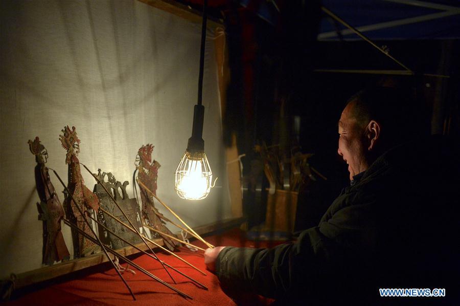 Zhang Guobin plays the shadow puppet performance at Luyuan Township of Weiyuan County in Dingxi City, northwest China\'s Gansu province, March 12, 2019. Many local folk artists concentrate on inheriting and passing down the folk art of shadow puppet performing and making in Gansu. They devote themselves to the study of the art and also organize various events to popularize the art. (Xinhua/Li Xiao)