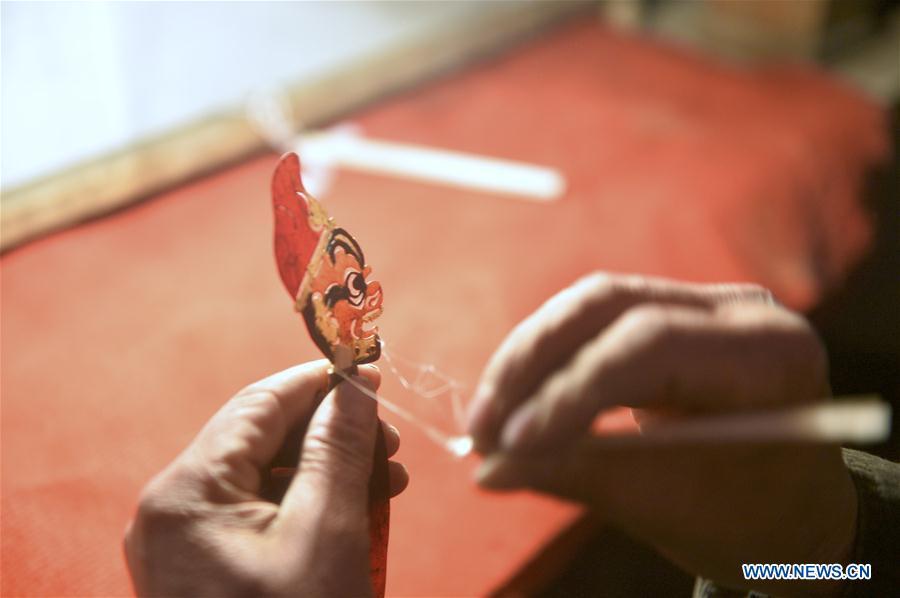 Zhang Guobin prepares for the shadow puppet performance at Luyuan Township of Weiyuan County in Dingxi City, northwest China\'s Gansu province, March 12, 2019. Many local folk artists concentrate on inheriting and passing down the folk art of shadow puppet performing and making in Gansu. They devote themselves to the study of the art and also organize various events to popularize the art. (Xinhua/Li Xiao)
