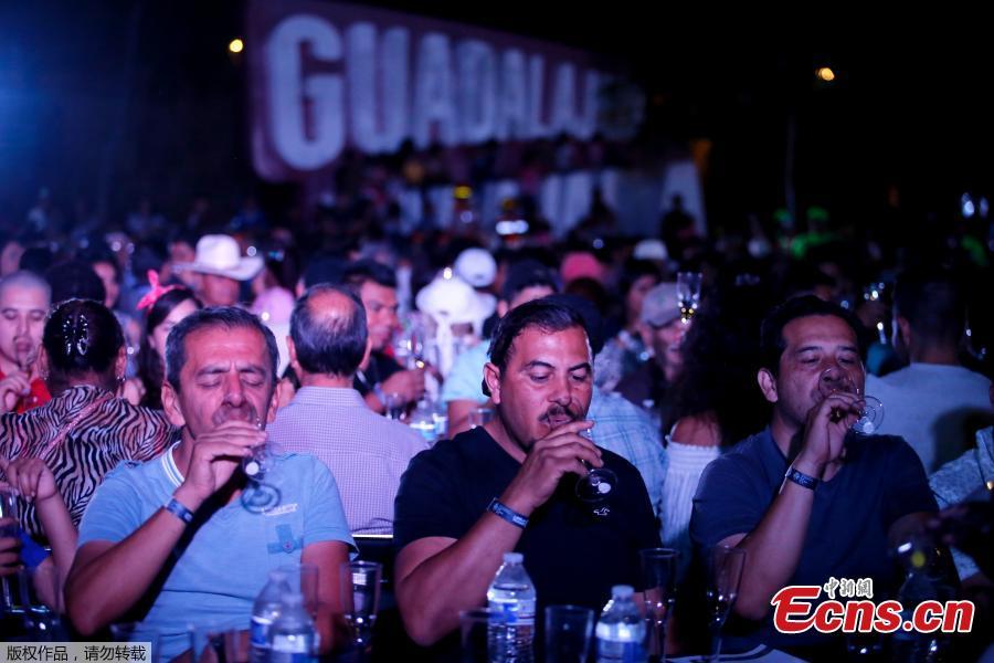 People drink tequila as 1,486 people gather to hold a tequila tasting at the Plaza Liberacion in Guadalajara, Jalisco, Mexico, on March 24, 2019 in an attempt to set a new Guinness World Record for the \