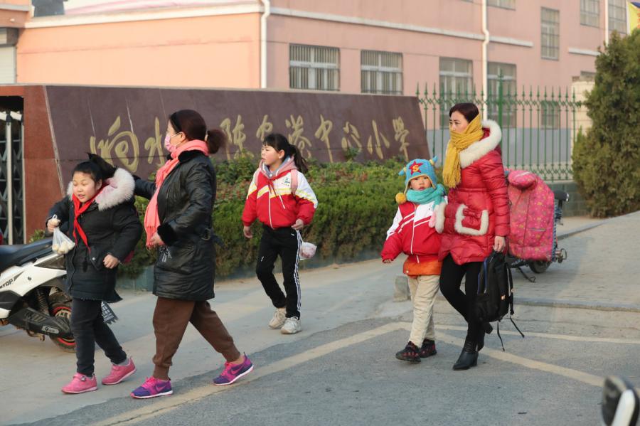 Parents send their children to school in Xiangshui county in Yancheng, Jiangsu province, on March 25, 2019. An industrial park explosion occurred in the county on March 21, killing 78. (Photo/chinadaily.com.cn)