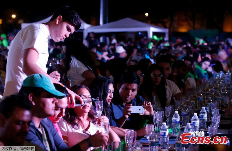 A man serves tequila as 1,486 people gather to hold a tequila tasting at the Plaza Liberacion in Guadalajara, Jalisco, Mexico, on March 24, 2019 in an attempt to set a new Guinness World Record for the \