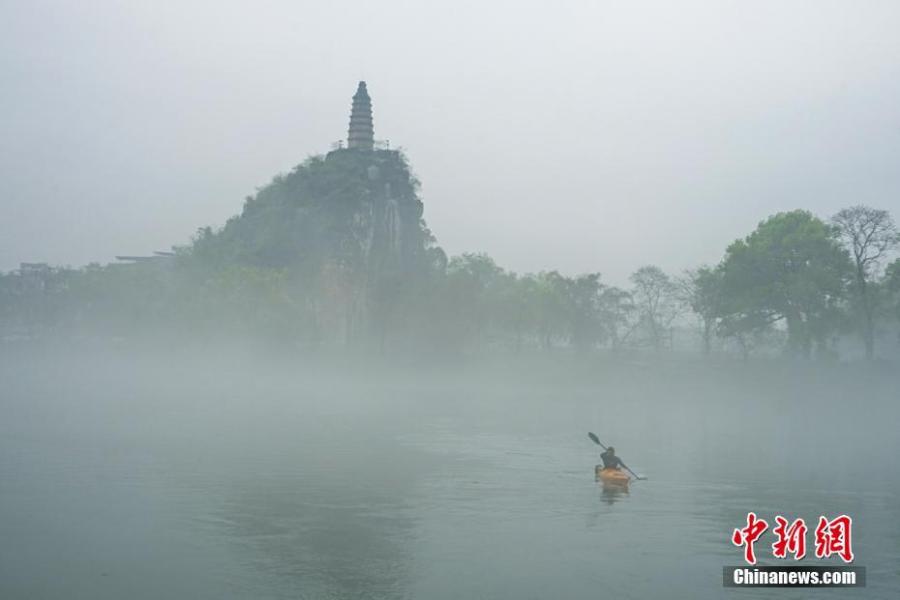 A view of Tashan Mountain surrounded by mist along the riverbanks of the Lijiang River in Guilin City, Guangxi Zhuang Autonomous Region, March 28, 2019. Like a green ribbon flowing through the mountains, the Lijiang River is known for its amazing natural beauty. (Photo: China News Service/Tang Mengxian)