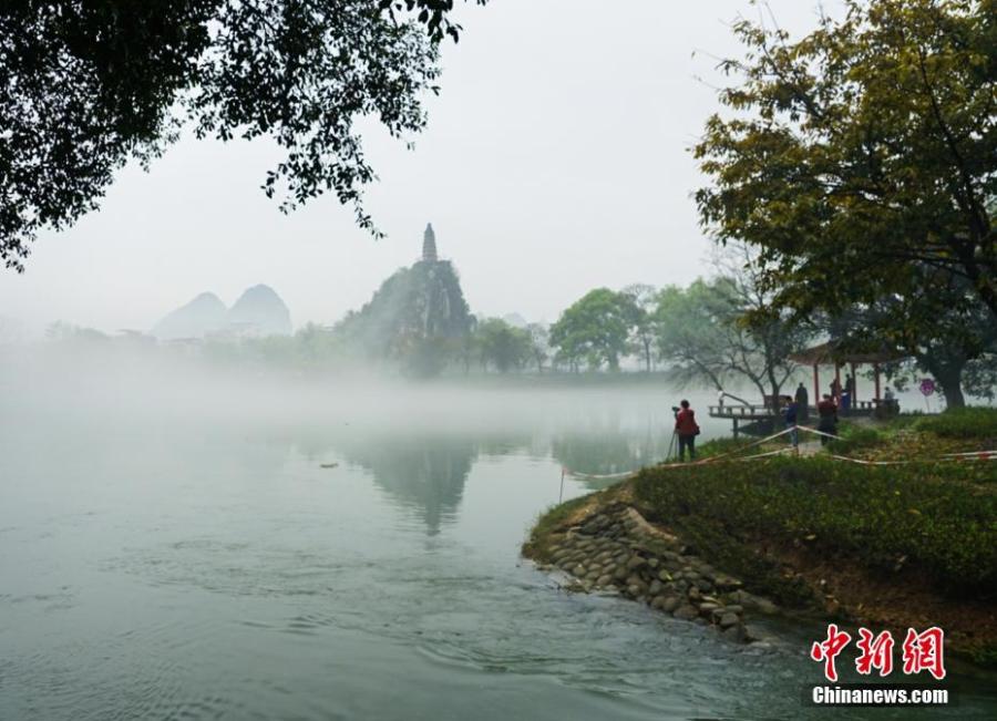 A view of Tashan Mountain surrounded by mist along the riverbanks of the Lijiang River in Guilin City, Guangxi Zhuang Autonomous Region, March 28, 2019. Like a green ribbon flowing through the mountains, the Lijiang River is known for its amazing natural beauty. (Photo: China News Service/Tang Mengxian)
